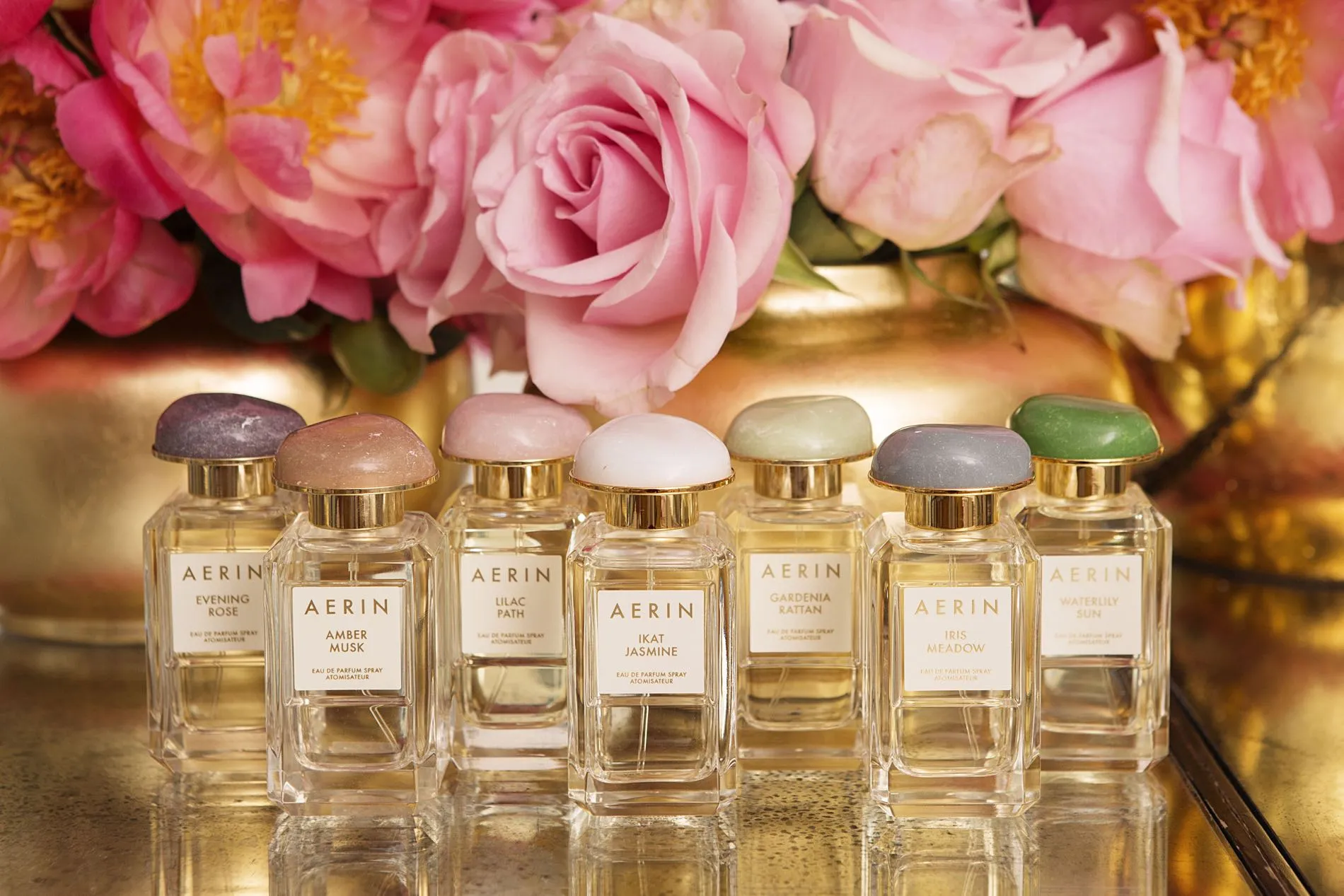A beautifully arranged bouquet of vibrant flowers accompanied by elegant perfume bottles
