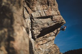 Active recreation example for a traveler - a tourist climbs a huge rock