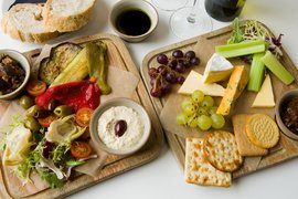 Wooden boards with treats from travels with cheeses, pickles, cheeses and fruits
